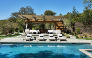 Poolside view of four white chairs in a vineyard estate