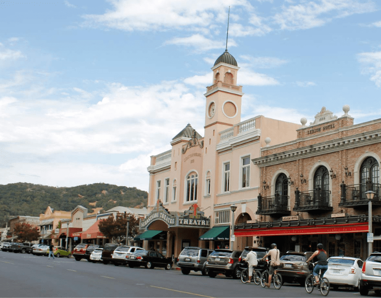 bicyclists ride along the sonoma plaza with the sebastian theatre in the background